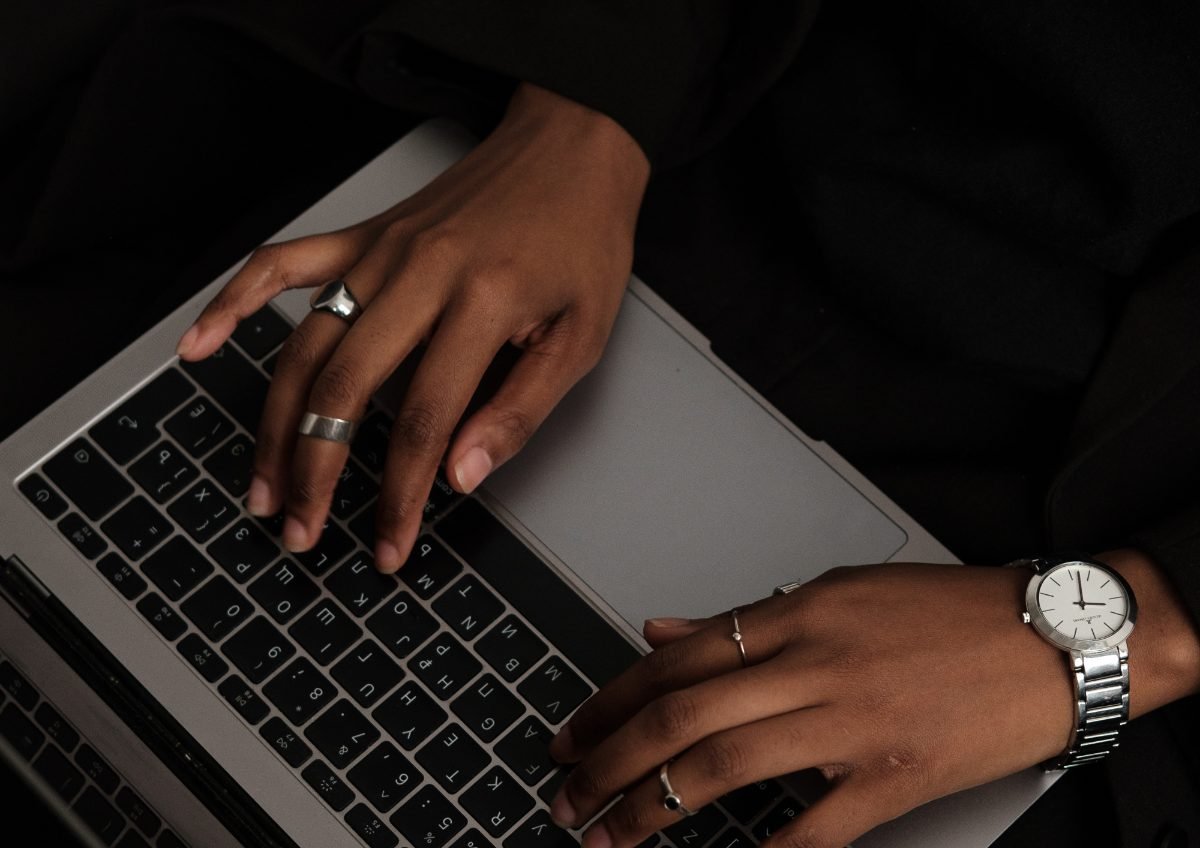 Hands typing on a laptop late at night