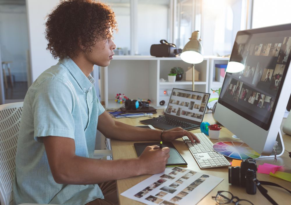 A designer crafting the new identity across screens
